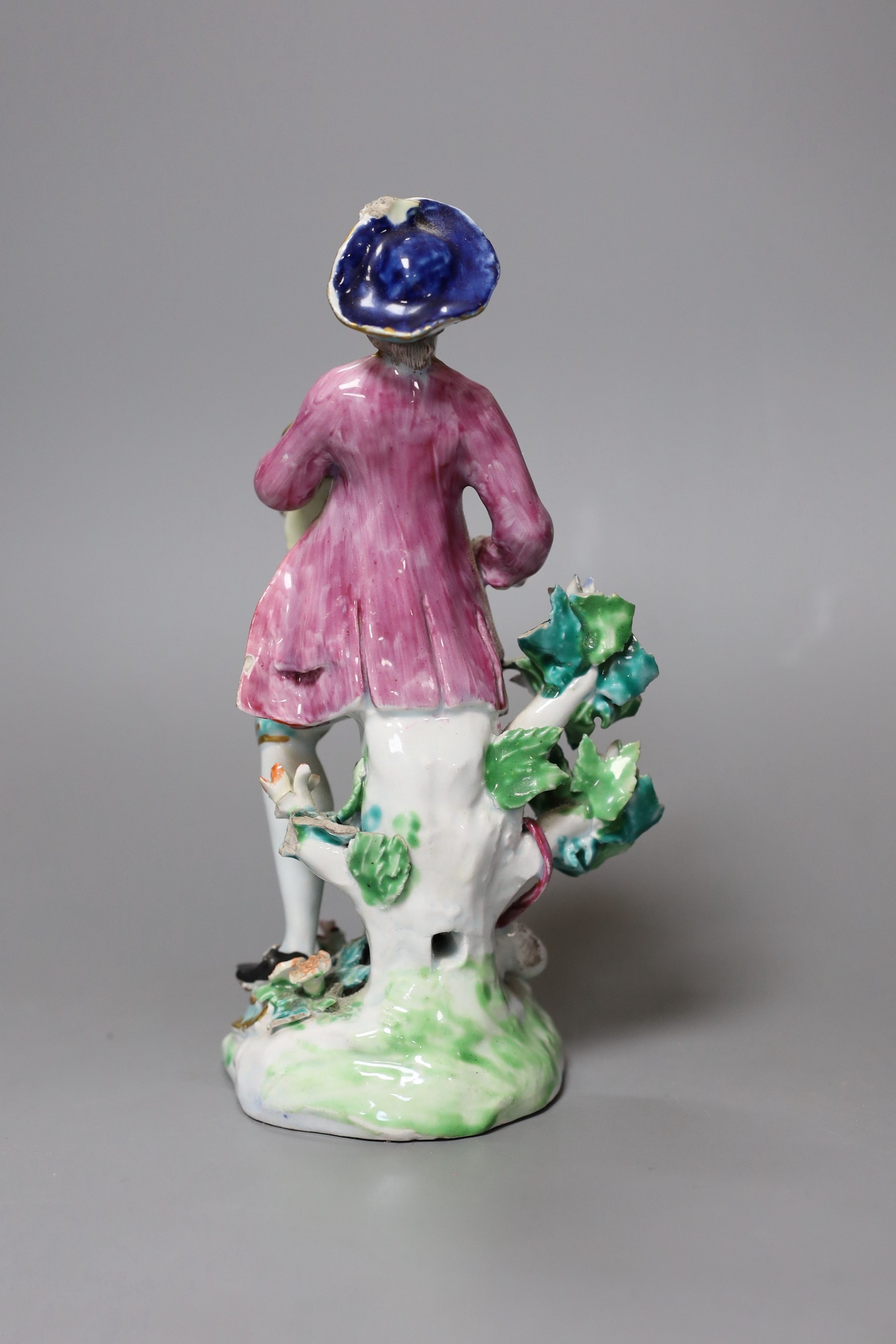 A Bow figure of a young man blowing a pipe and beating a tabor, 20cm tall